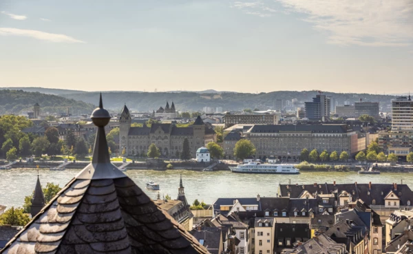 Ausblick über Koblenz vom Stadtteil Ehrenbreitstein aus mit mehreren Türmen, dem preußischen Regierungsgebäude, dem Pegelhaus und dem Rhein im Blick